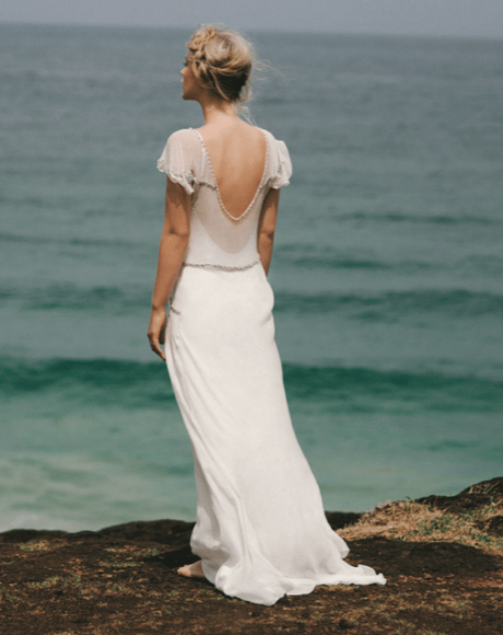 The Iona gown by Amanda Garrett is truly stunning. Silk chiffon gown with hand applied crystal draped beading detail on neckline sleeves and drop front waistline, utterly unique, worn here with silk low back slip, may be ordered with a higher back. This designer wedding dress is available to try on at The Barefaced Bride studio.