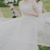Breathtaking and unique Charlotte gown by Reem Acra. This stunning gown features an illusion neckline and nude lining. Lace bodice with off the shoulder sleeve and romantic tulle. This preloved Reem Acra gown is available to try on at The Barefaced Bride studio.